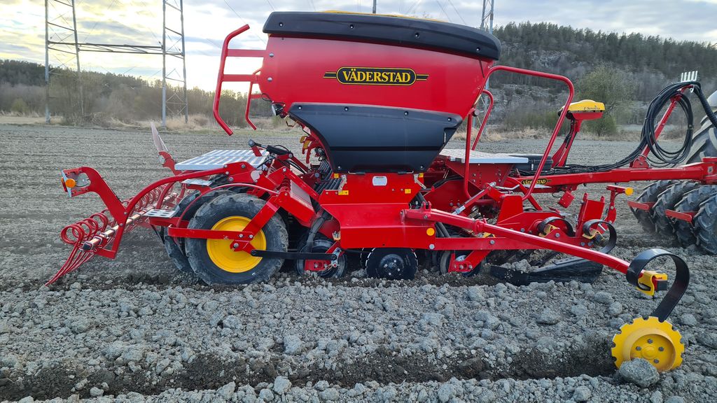 Rød kombisåmaskin på et jorde. Foto.