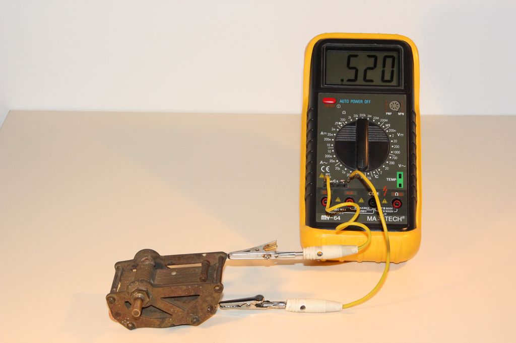Digitalt måleinstrument som måler på en metallenhet ved hjelp av ledninger. Foto.
