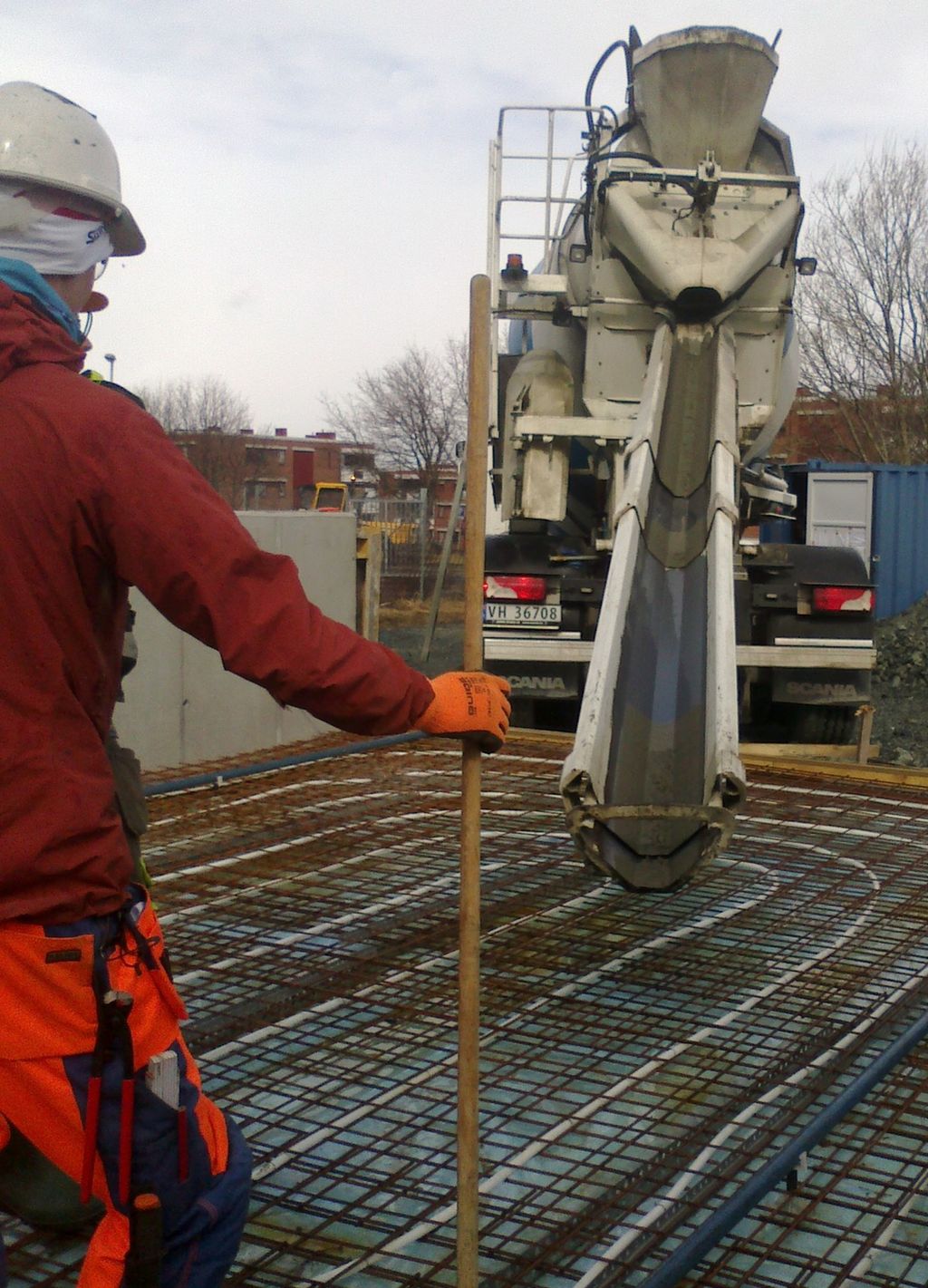 Bildet viser en betongarbeider og en betongbil med renne.