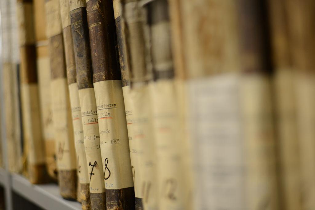 Ryggen på gamle arkivbøker der det står Sorenskrivaren i Follo på.  Foto.