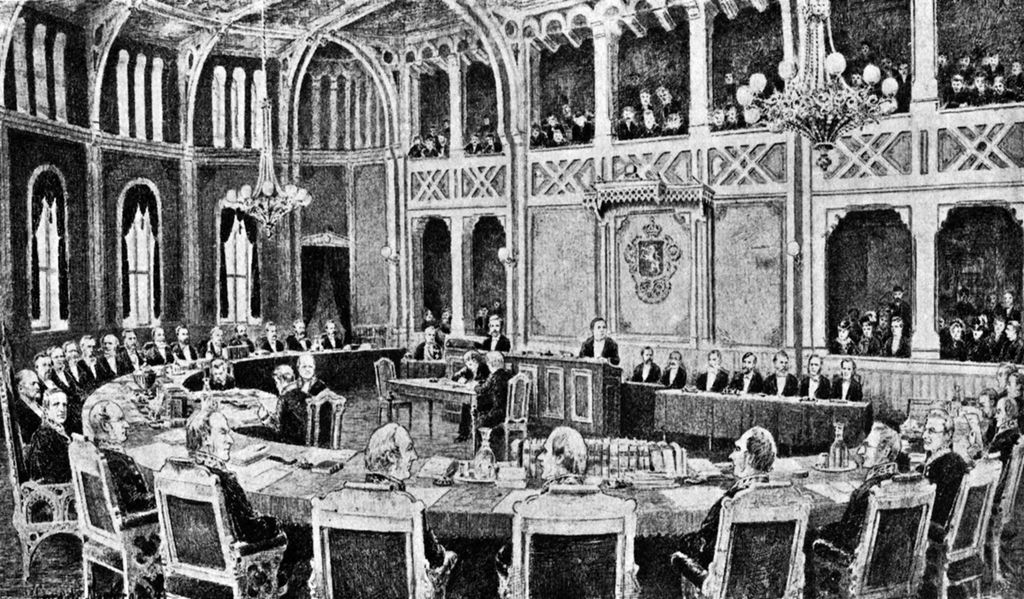 Framstilling av møtet i Riksretten 1884. Mange menn sitter i en halvsirkel og noen på rekke fremst i salen. På galleriene sitter det tett i tett med tilhørere. Illustrasjon.