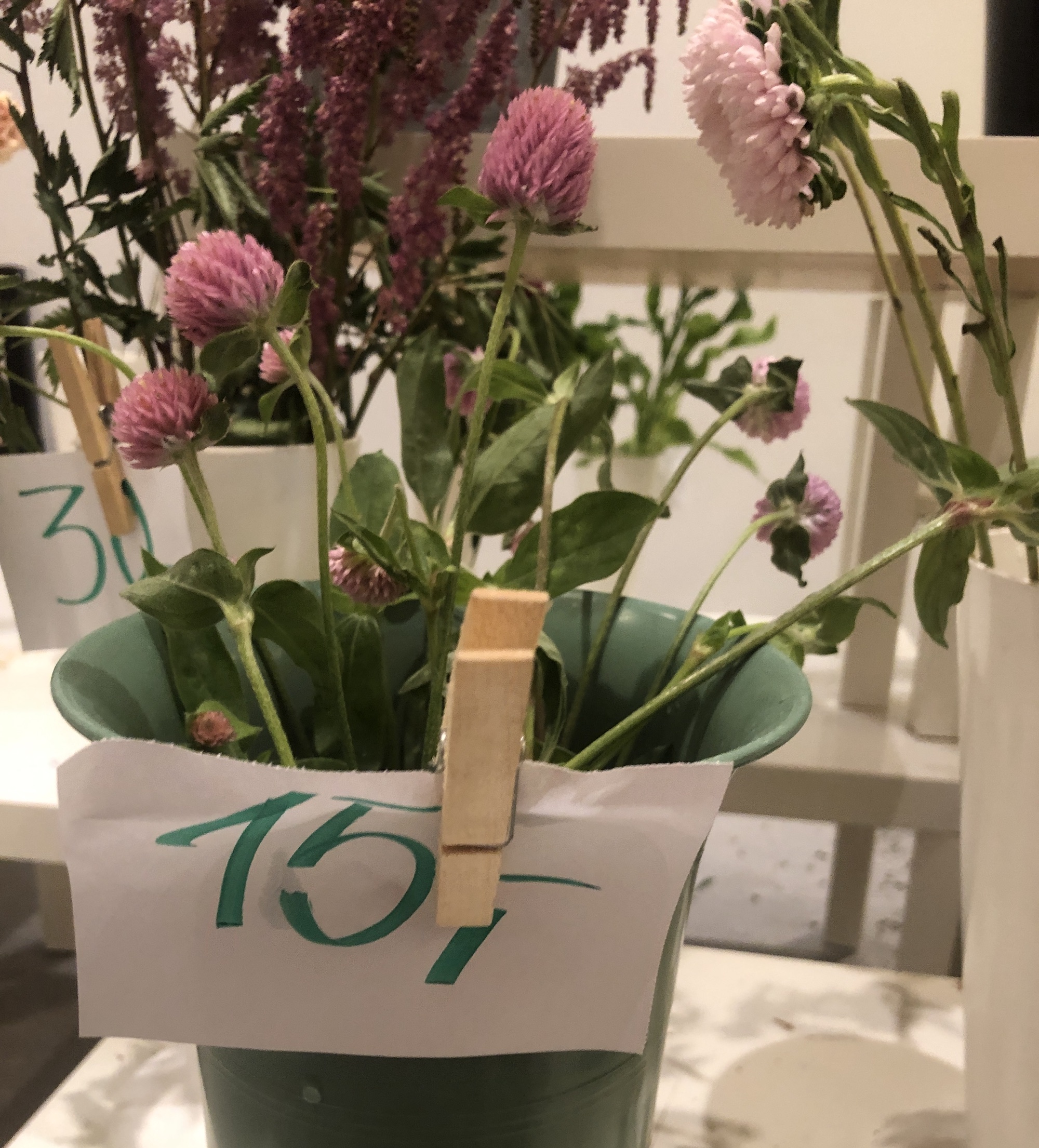Blomster i vaser. Til vasene er det festet papirlapper med pris. Foto.