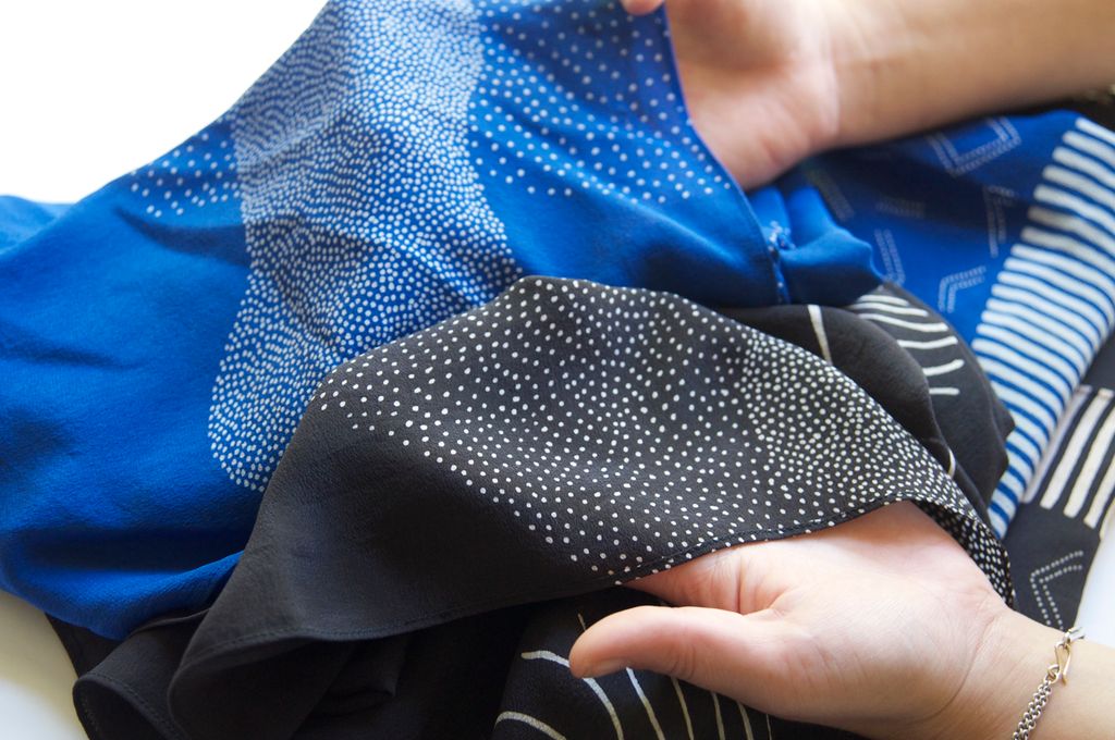 Blått og svart tekstil med hvitt mønster. Foto.