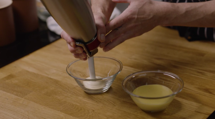 En hollandés på espumaflaske som sprøytes ut i en liten bolle. Foto.