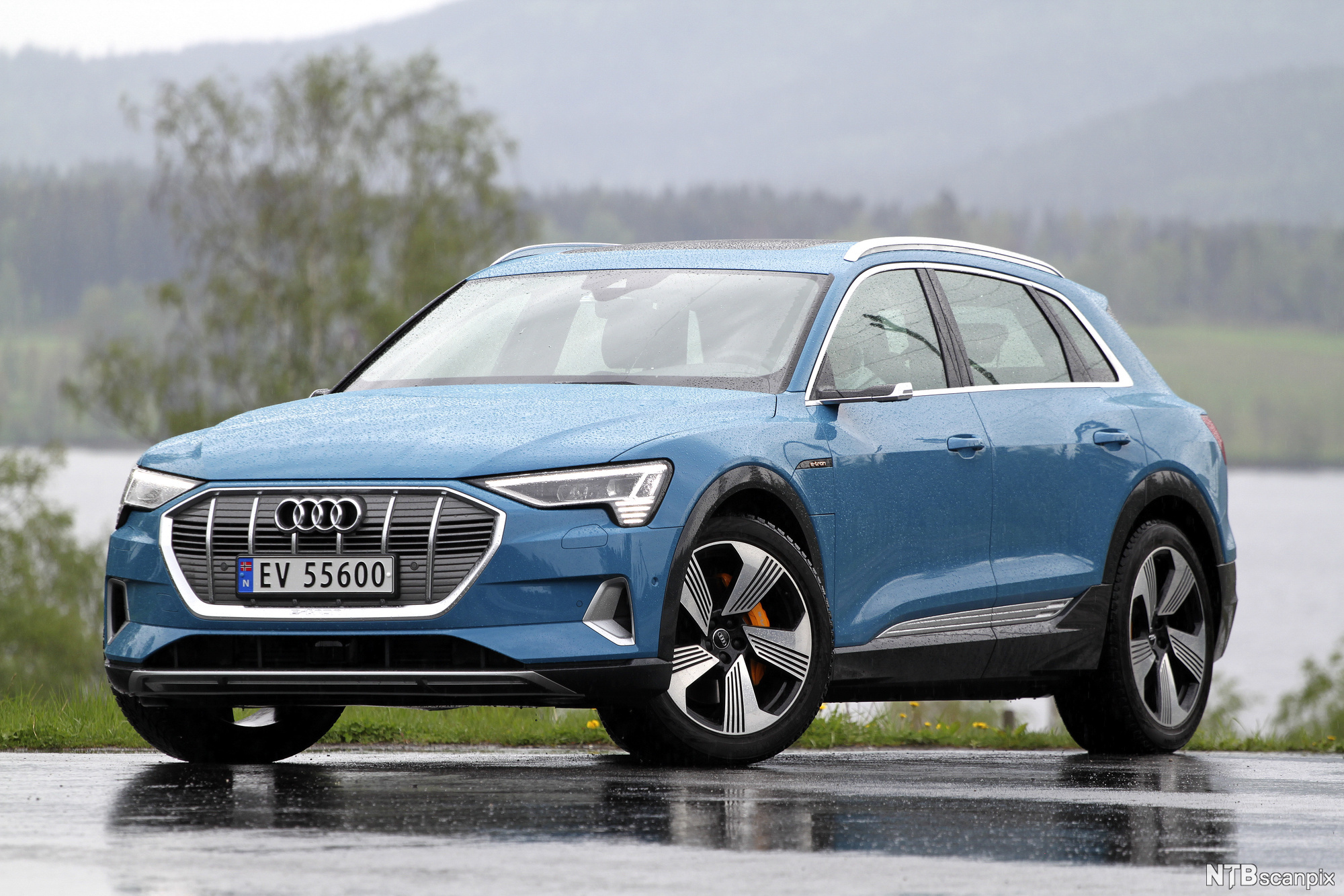 Blå bil av merket Audi e-tron på en parkeringsplass. Foto.