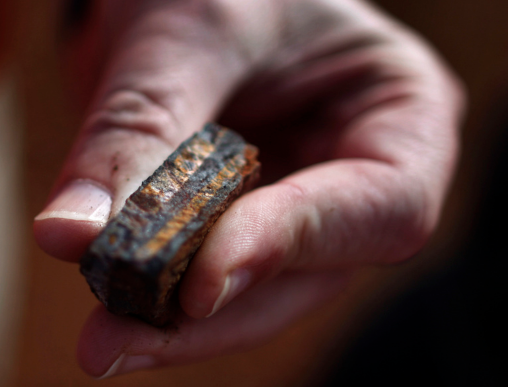 Hånd som holder en jernformasjon. Foto.