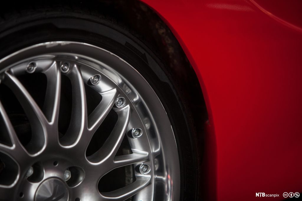 Forkrommet bilfelg på rød bil. Foto.