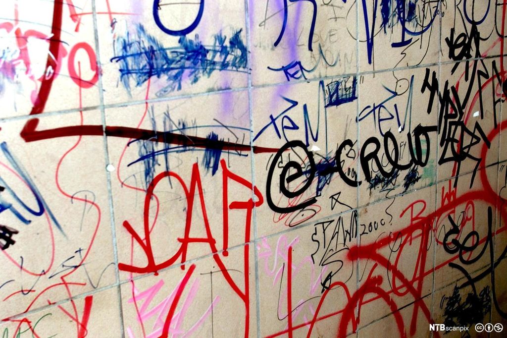 Grafitti i ulike farger i en undergang. Foto.