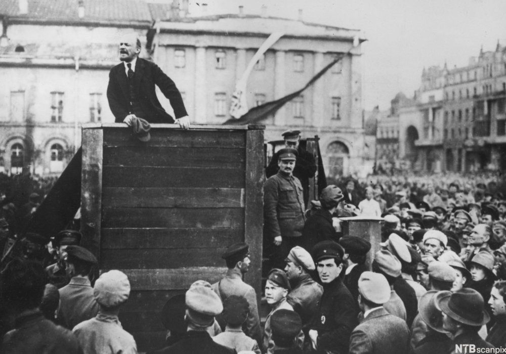 Lenin og Trotskij foran en stor folkemengde i Moskva i 1920. Lenin står på talerstolen med Trotskij ved siden av. Foto. 