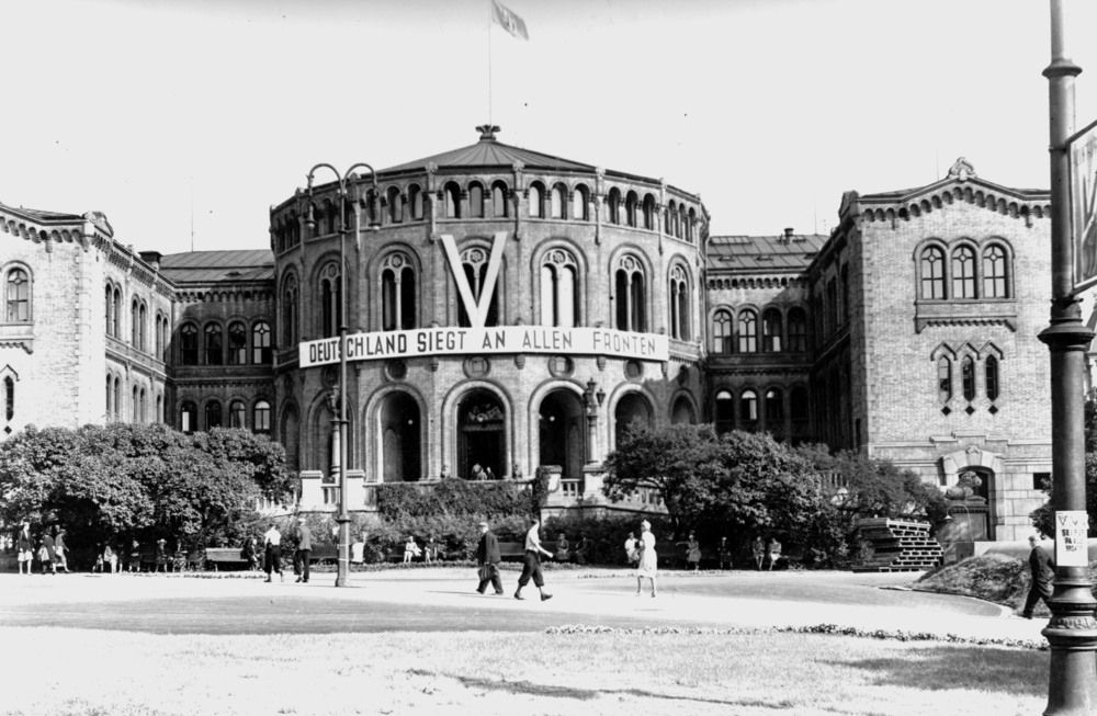 Et langt banner med påskriften: ”Deutschland siegt an allen Fronten”, eller på norsk: "Tyskland seirer på alle fronter" går over hele midtpartiet på Stortinget.  Svart-hvitt-foto.