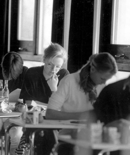 Elevar sit ved pultar og skriv. Foto.