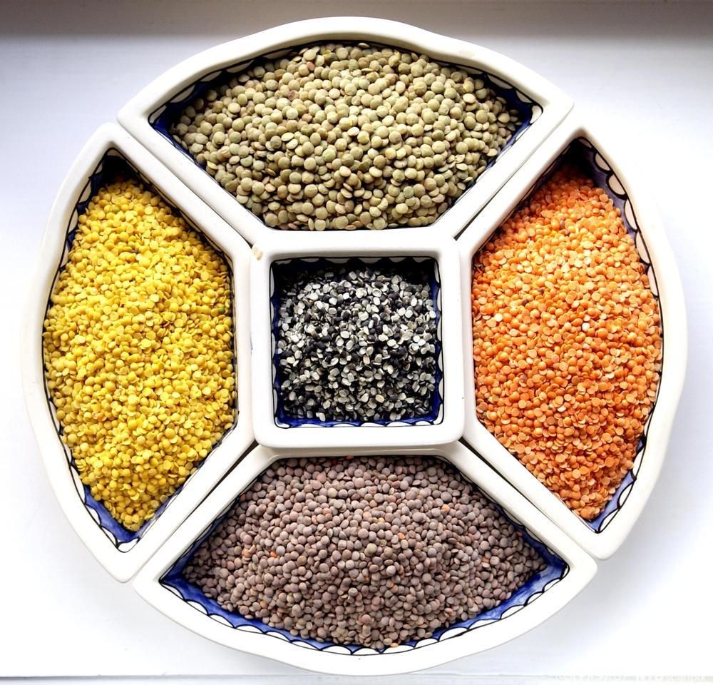 Ulike typer linser ligger i hver sine rom i et fat. Foto.