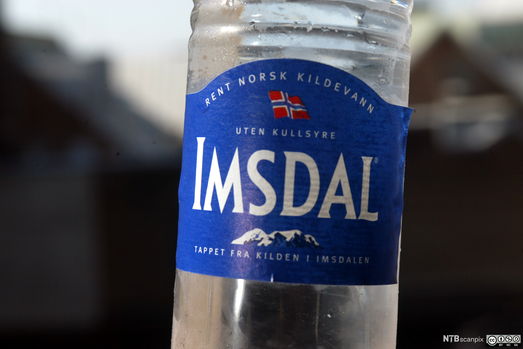 Nærbilde av en flaske Imsdal-vann. Foto.