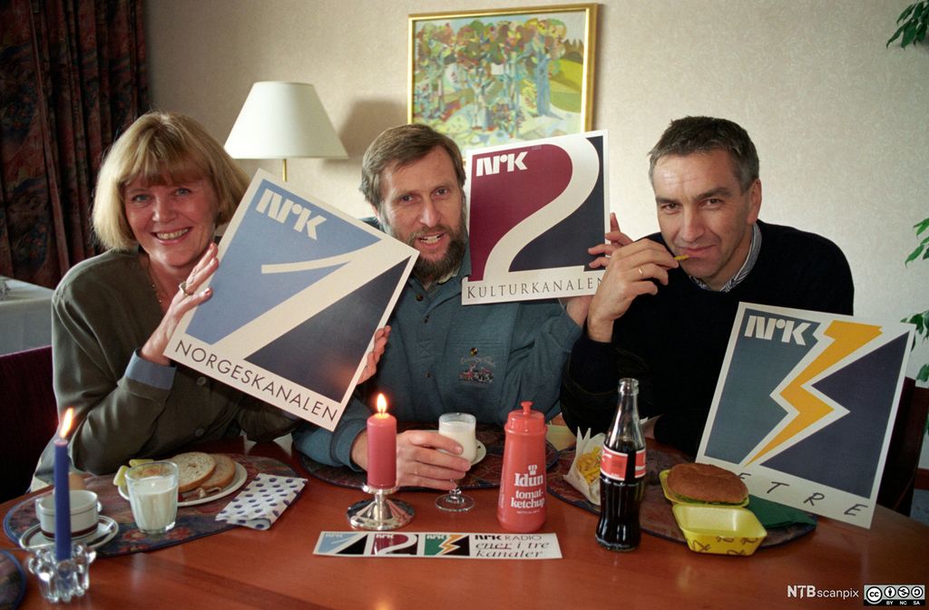 NRKs tre radiokanalprofiler i 1993. Kanalsjefene holder opp hvert sitt skilt med henholdsvis Norgeskanalen (P1), Kulturkanalen (P2) og Petre (P3). Foto.