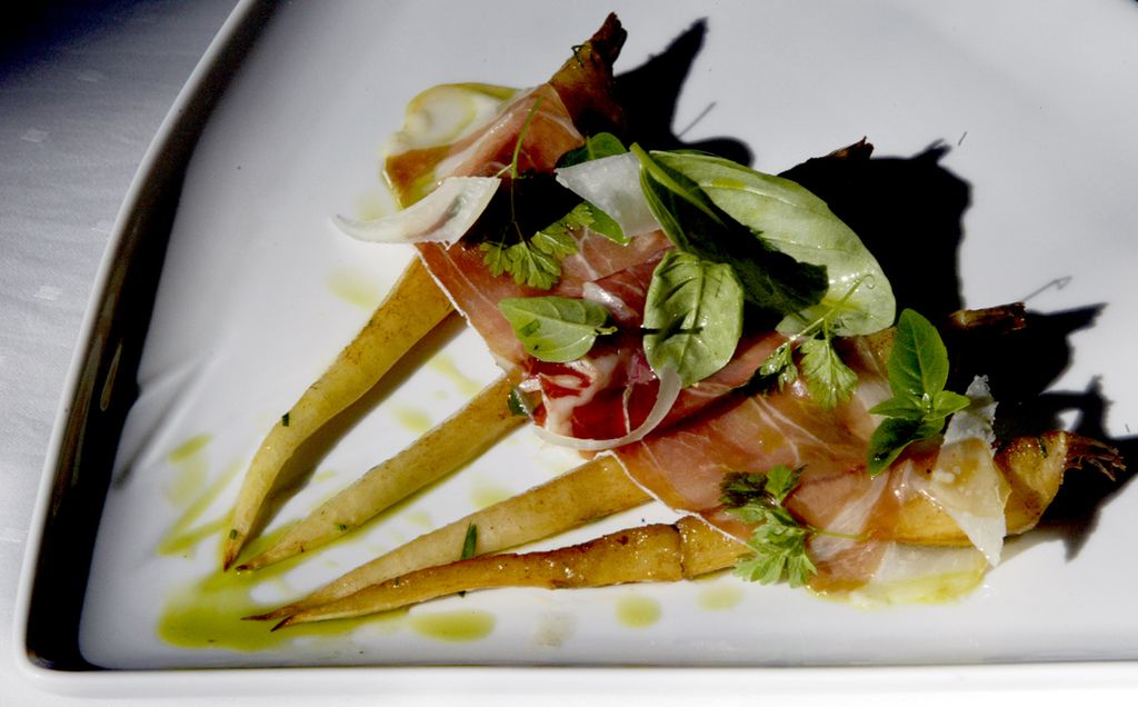 Persillerot delt i fire anrettet med skinke og grønne urter. Foto.