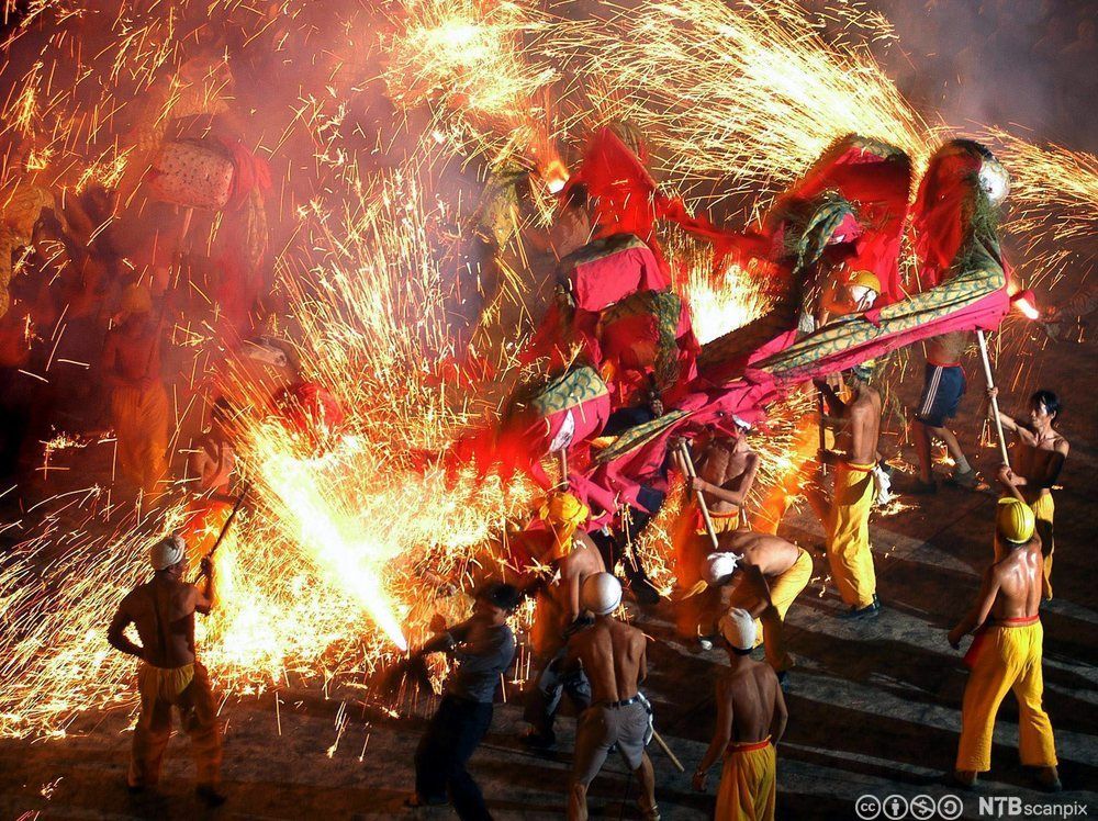 Etniske shui-dansere utfører den tradisjonelle dragedansen med drager og fyrverkeri. Foto.