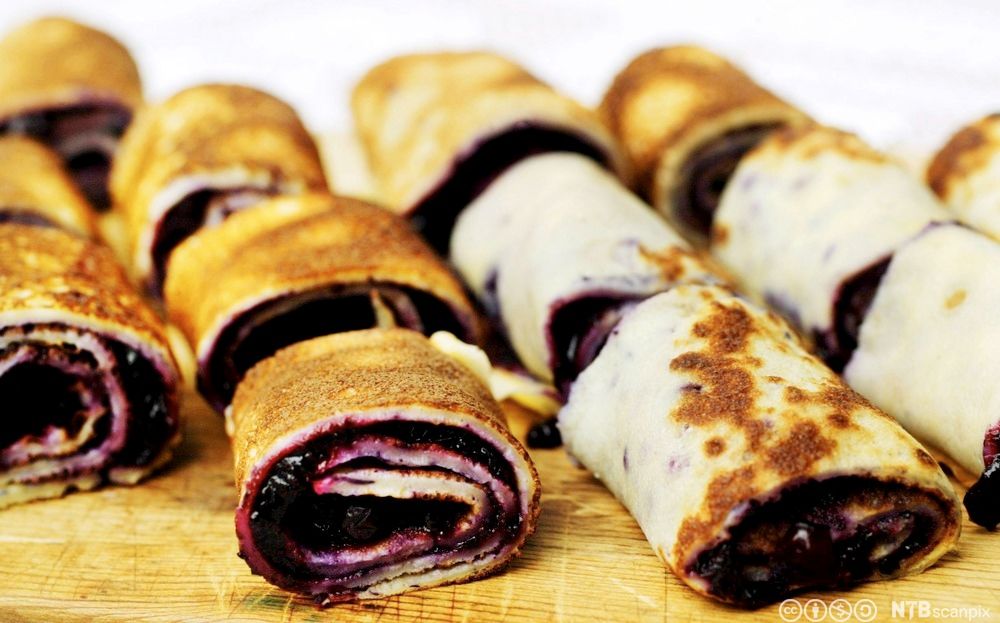 Pannekaker med blåbær på ei fjøl, rulla saman og kutta opp i mindre bitar. Foto.