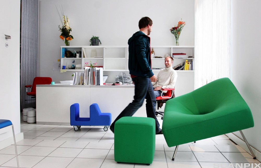 Mennesker og møbler på et gulv. Foto.