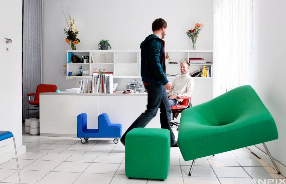 Folk og møblar på eit golv. Foto.