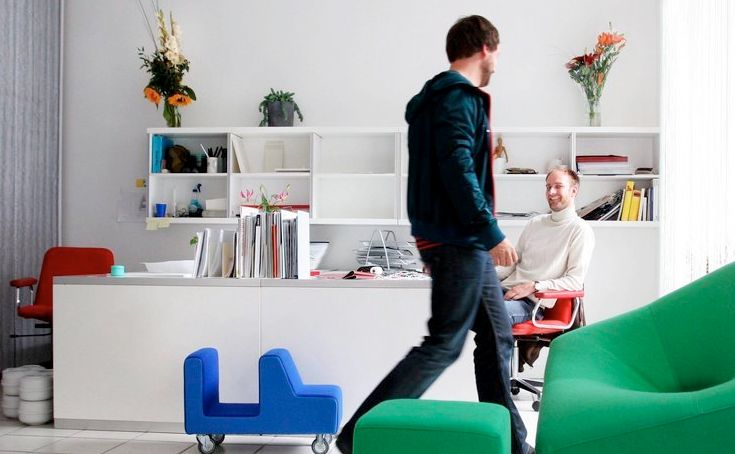 Mennesker og møbler på et gulv. Foto.