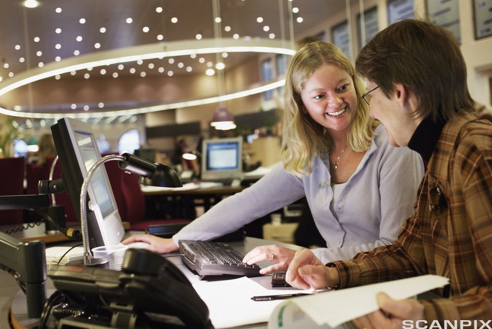 To kvinner i dialog foran en skjerm. Foto.