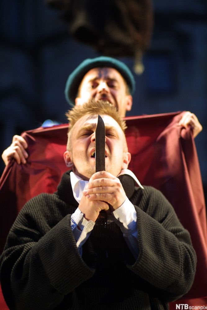 Scene frå Shakespeares drama Hamlet der Hamlet held ein dolk med begge hender. Foto.