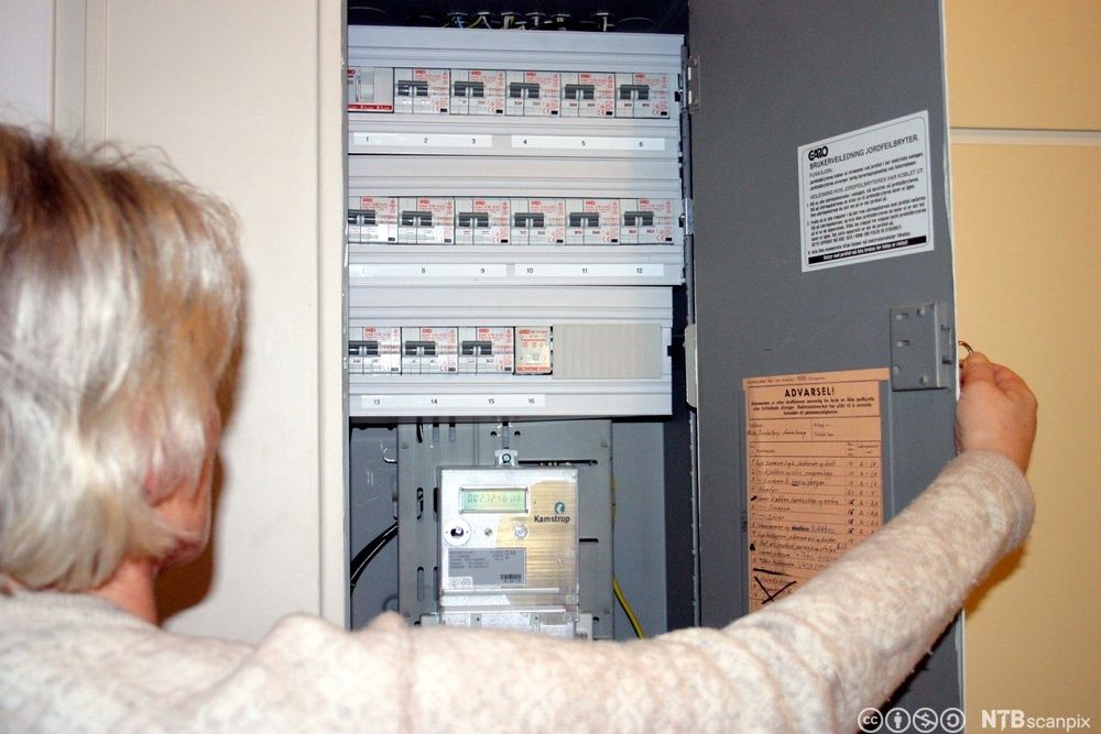 Kvinne åpner et sikringsskap. Foto.