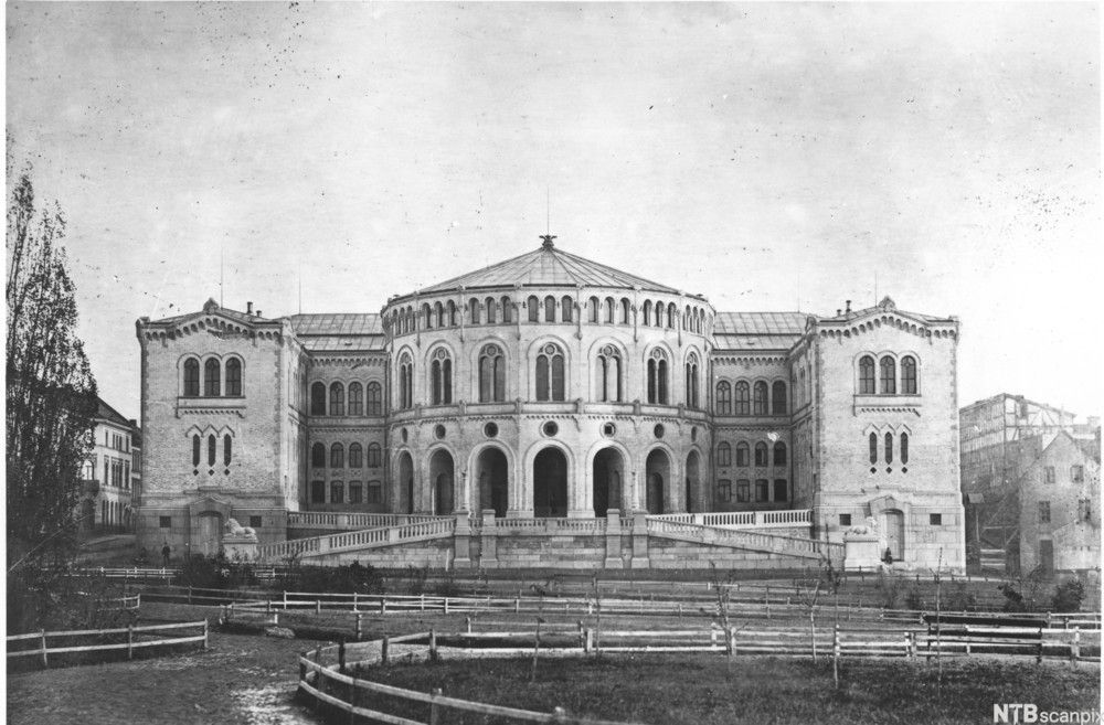 Foto av Stortingsbygningen fra 1861. Gangveier og parkanlegg i front. 