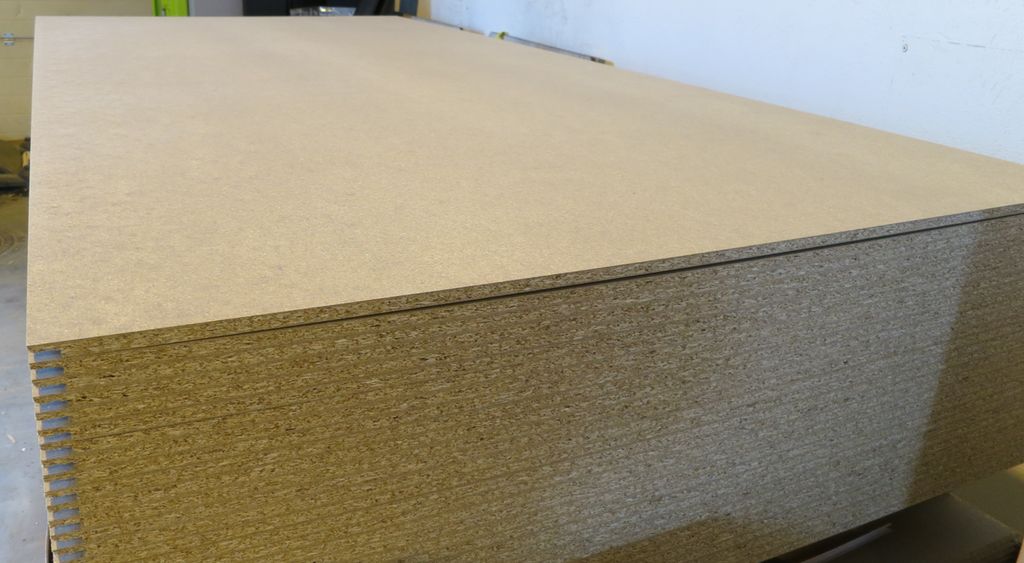 Stabel med sponplater til vegg. Foto.