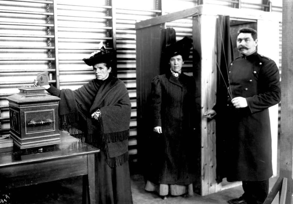 Alvorlig kvinne legger seddel i stemmeurne. Foto. 