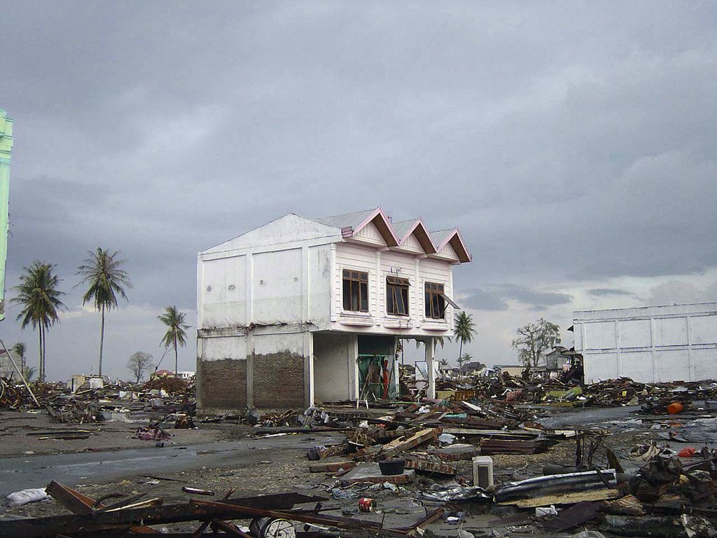 Øydeleggingar i Banda Aceh i Indonesia etter tsunamien i 2004. Ein del av eit hus står igjen, med haugar av skrot rundt. Foto. 