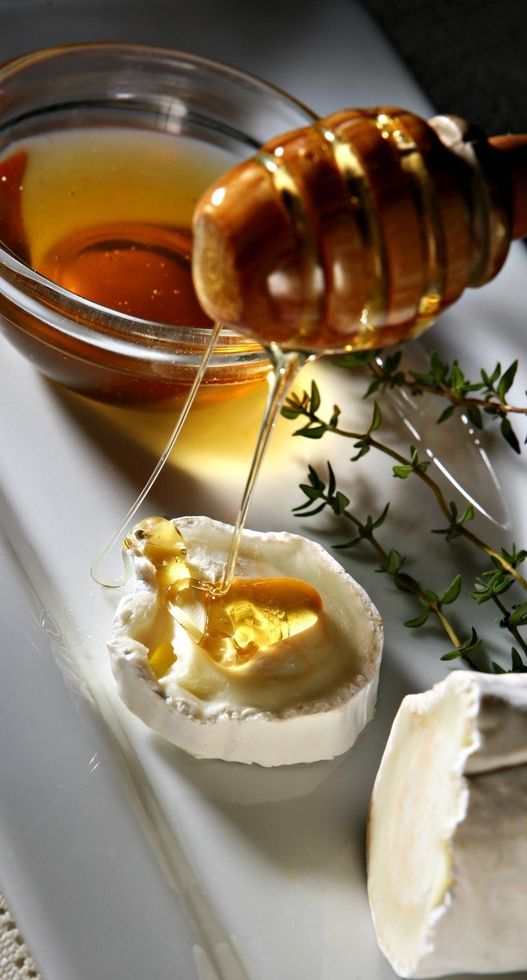 Honning renn over ein bit chèvre. Foto.