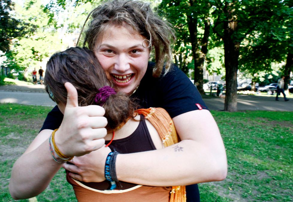To som gir kvarandre ein god klem. Den eine ser inn i kameraet og viser tommel opp. Foto.