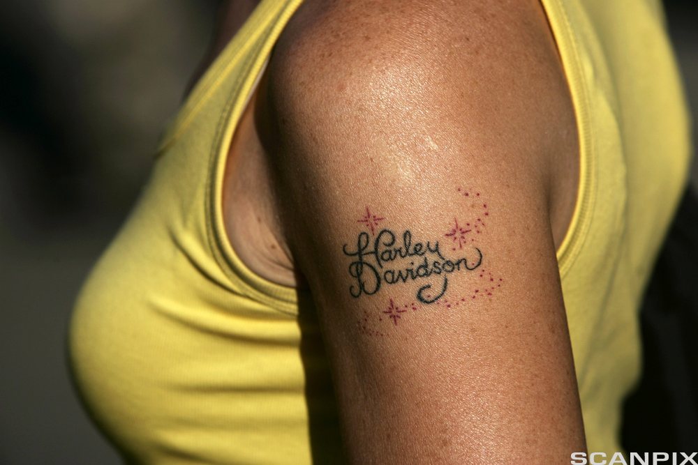 Solbrun overarm med merkenavnet Harley Davidson tatovert. Foto.