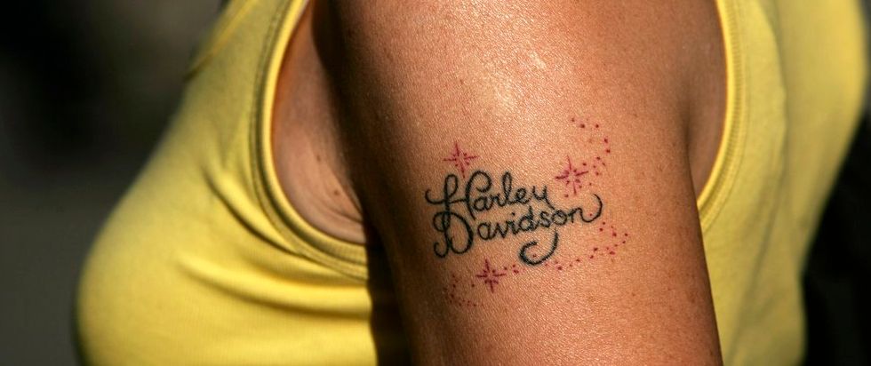 Solbrun overarm med merkenamnet Harley Davidson tatovert. Foto.