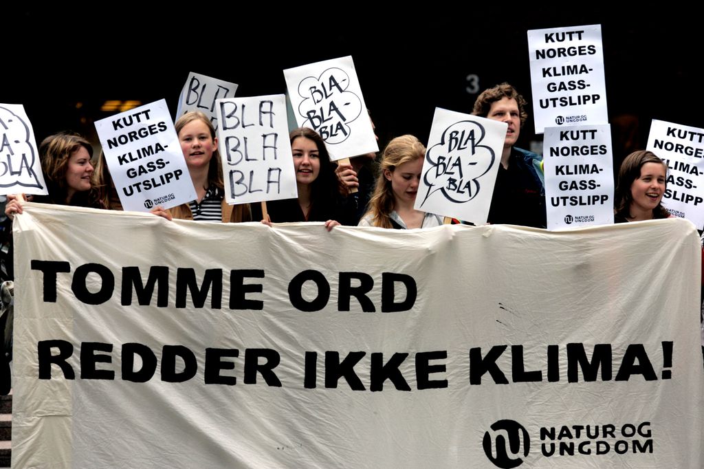Demonstranter fra Natur og ungdom bærer banner og plakater med titler som "Tomme ord redder ikke klima". Foto.