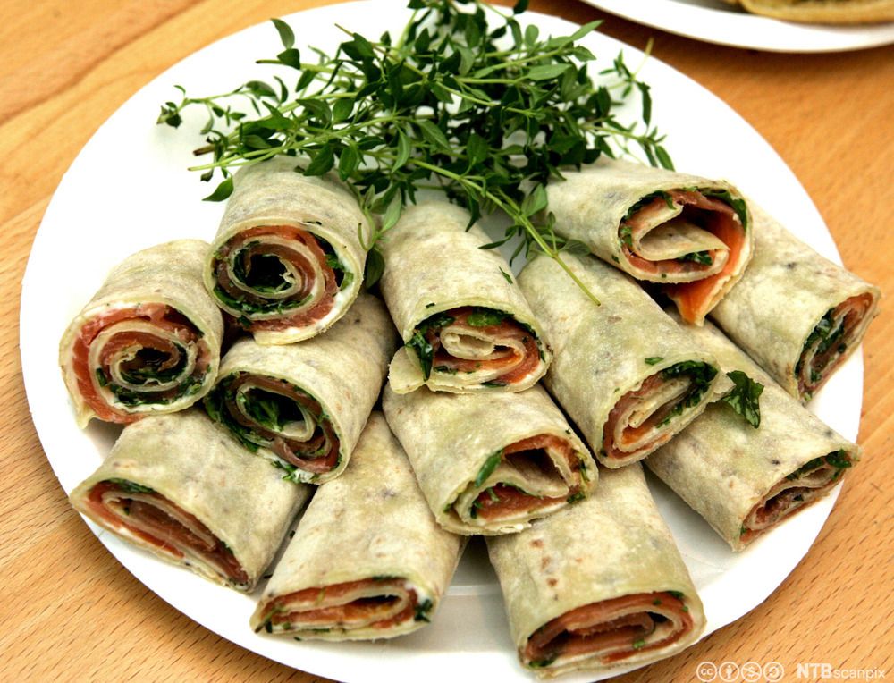 Sammenrullede potetlefser som er fylt med urter, røykelaks og smøreost. Foto.