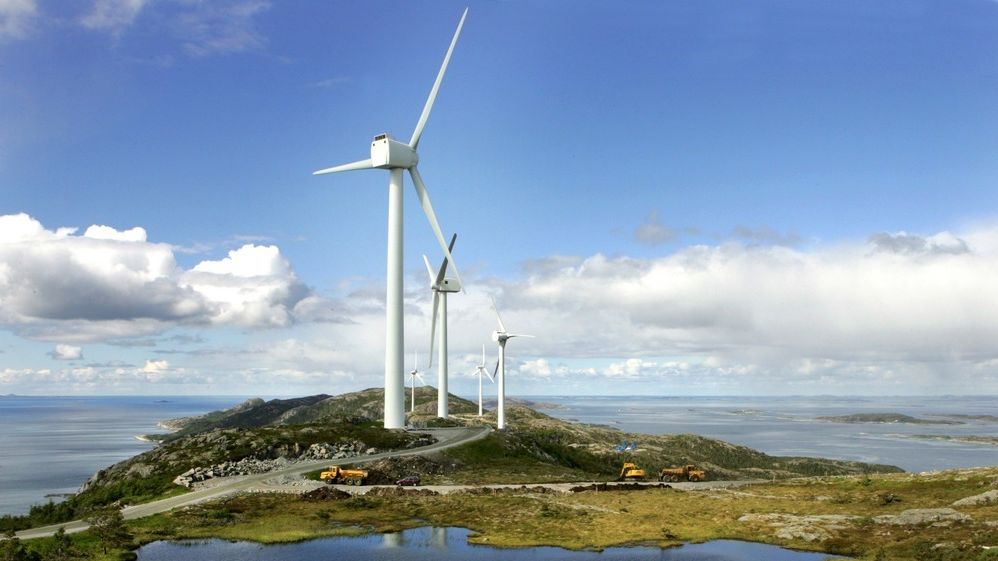 Fem vindmøller i kystlandskap. Foto.