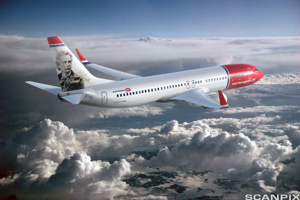 Et fly i lufta, over ulike skyformasjoner. På flyet står det Norwegian. Foto.
