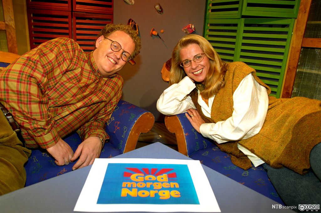 En mann og en dame med logoen til programmet God morgen Norge mellom seg. Foto.