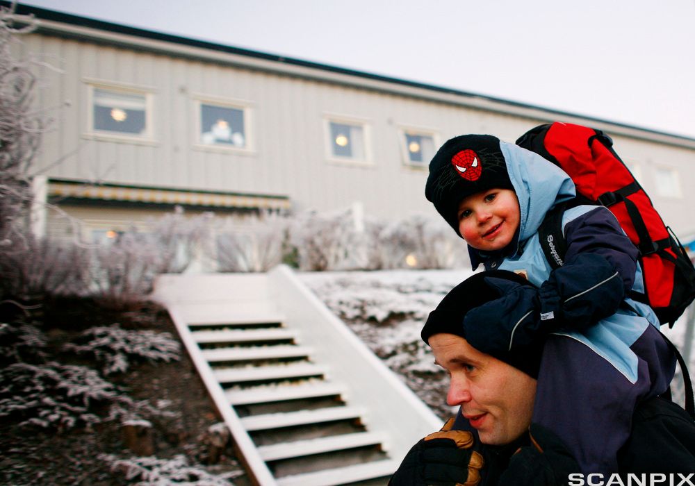 Far med barn på skuldrene. Foto.