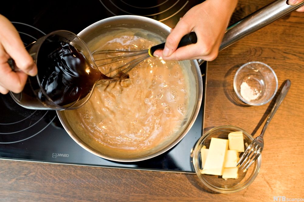En brun saus i ei gryte spes med kraft. Foto.