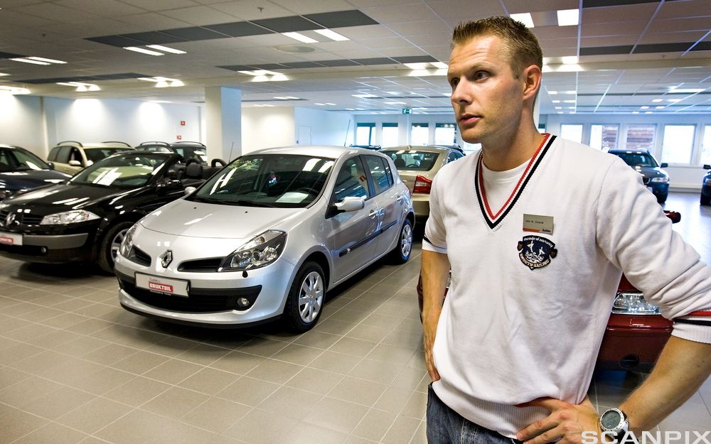 En bilselger i salgshallen. Foto.