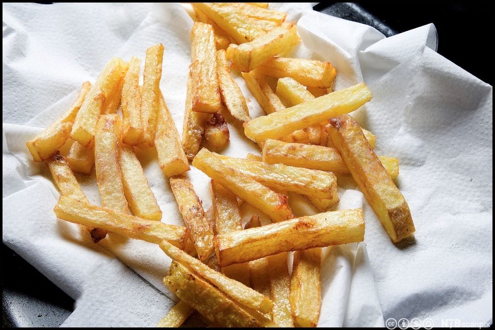 Hjemmelaget pommes frites på et hvitt klede. Foto.