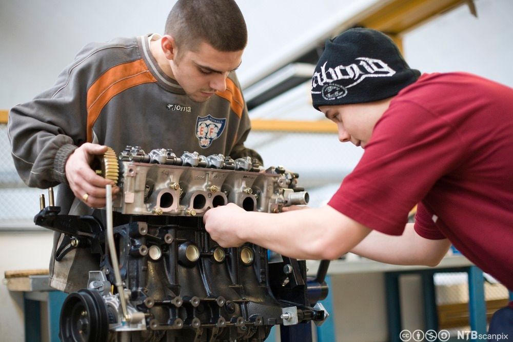 Bil på verksted, elever i dyp konsentrasjon. Foto.