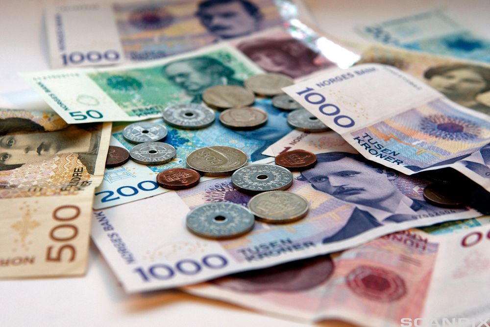 Pengesedler og mynter på et bord. Foto.