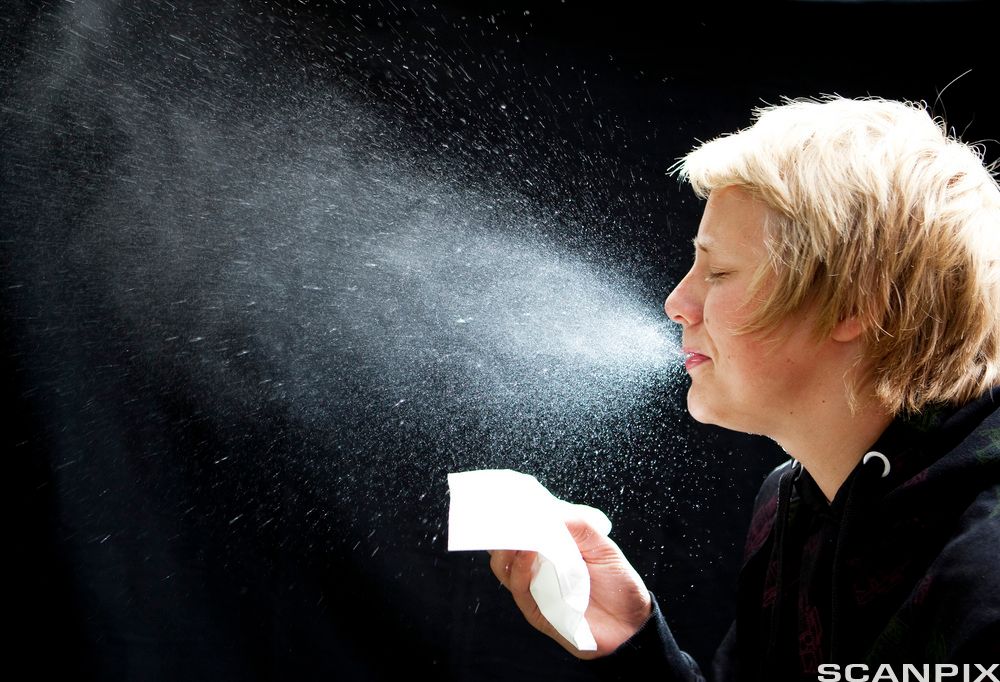 Kvinne som nyser. Foto.