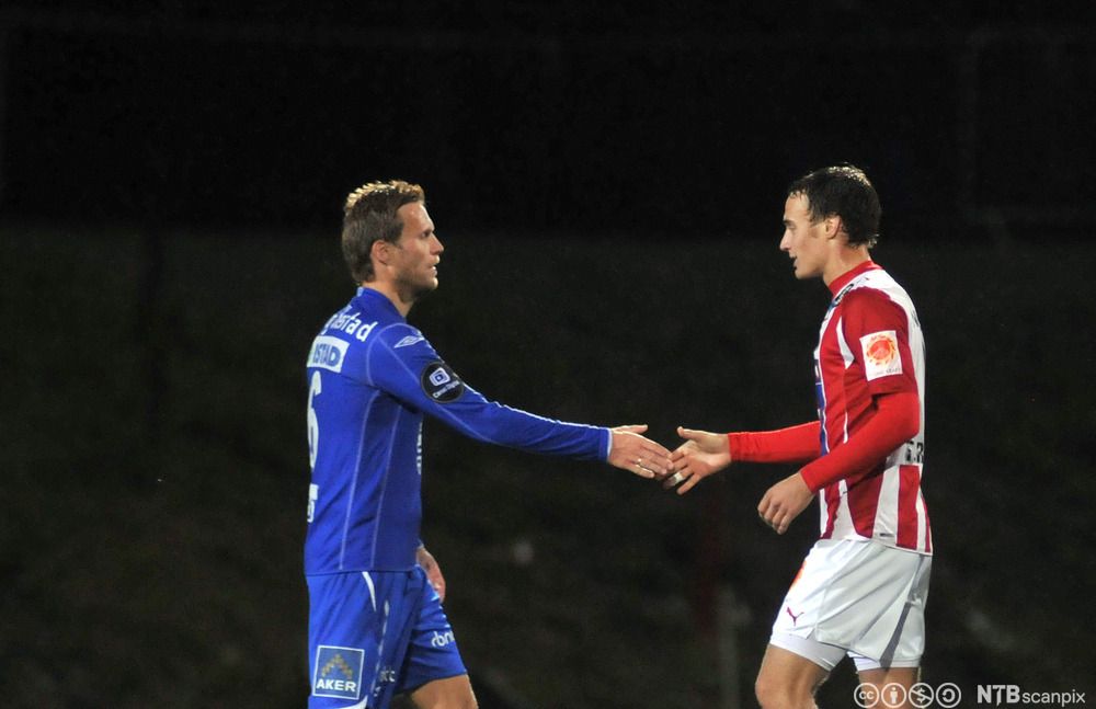 Tore Reginiussen i rød drakt og Daniel Berg Hestad i blå drakt takker for kampen. Foto.