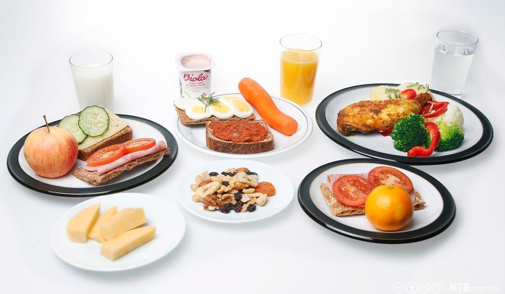 Tallerkener med matvarer som passer i en nøkkelrådskost, blant annet grove kornprodukter, grønnsaker, frukt, egg, kylling, fiskepålegg og magert pålegg. Foto.