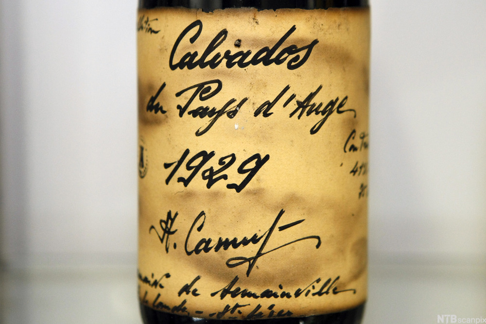 En håndskrevet etikett på en flaske calvados fra 1929. Foto.